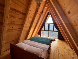 Bett in einem Zimmer mit einem großen Fenster in der Unterkunft Pera Bungalov in Ardeşen