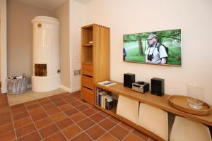 a living room with a television on a wall at Ohl Dörp 22 Pastoratshof, Haus 7 in Wrixum