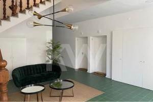 un salon avec un fauteuil en cuir noir et des tables dans l'établissement Casa Moliceiro Verde, à Aveiro