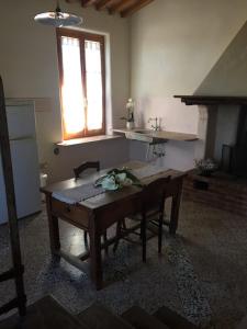 cocina con mesa de madera y ventana en CASALE LA BANDITA, en La Bandita