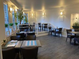 un restaurant avec des tables et des chaises ainsi qu'un bar dans l'établissement Hôtel de la Mer, à Pléneuf-Val-André