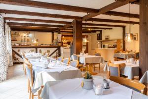 restauracja z białymi stołami i krzesłami w pokoju w obiekcie Gästehaus Kaltenbach w mieście Staufen im Breisgau