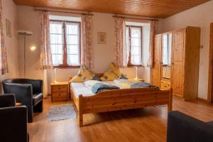 a bedroom with a wooden bed in a room with windows at Gästehaus Kaltenbach in Staufen im Breisgau