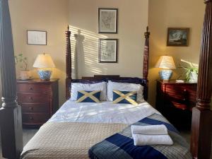 a bedroom with a bed with blue and yellow pillows at Lyndhurst - Victorian villa with heated pool in Roby