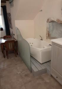 a white bath tub in a room with a table at Hamam Oriental Suites in Rethymno Town