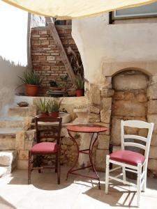a patio with two chairs and a table and a stone oven at Hamam Oriental Suites in Rethymno Town
