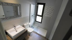 Un baño con lavabo, inodoro y espejo. en Casa D'Alessandro, en Orihuela Costa 20 fotos más