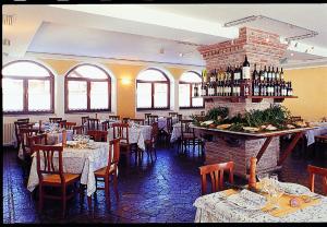 ein Restaurant mit Tischen und Stühlen und einem gemauerten Kamin in der Unterkunft Locanda Locatori in Passo del Tonale