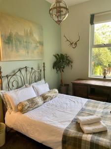 a bedroom with a bed with white sheets and a window at Lyndhurst - Victorian villa with heated pool in Roby