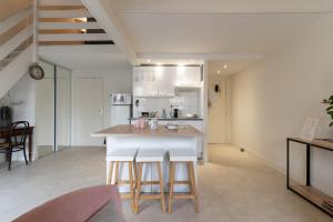 a kitchen with a counter and stools in a room at COSY Home - 2 à 4 pers - Aéroport - vieux Blagnac in Blagnac