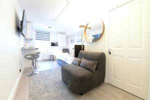 a living room with a chair and a mirror at London Studios Very Close to Central Line Underground Shepherds Bush and Westfield Newly Refurbished in London