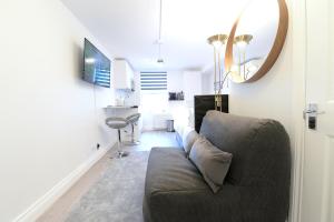 a living room with a couch and a desk at London Studios Very Close to Central Line Underground Shepherds Bush and Westfield Newly Refurbished in London