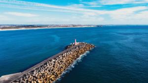 an island in the ocean with a lighthouse on it at Sea Garden Peniche in Peniche