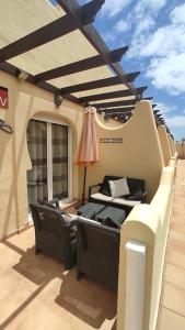 a patio with chairs and a table on a balcony at Casa Donn - El Sultán 63 - luxury 3 bed Villa with fast fibre internet in Corralejo