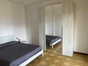 a bedroom with a mirror next to a bed at Casa del Faggio Rosso in Bellagio
