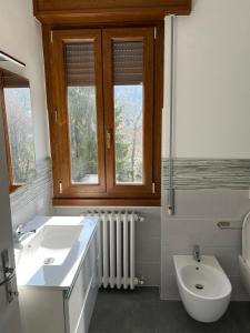 a bathroom with a sink and a toilet and a window at Casa del Faggio Rosso in Bellagio