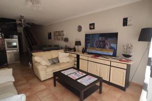 a living room with a couch and a flat screen tv at Casa Donn - El Sultán 63 - luxury 3 bed Villa with fast fibre internet in Corralejo