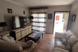 a living room with a couch and a tv at Casa Donn - El Sultán 63 - luxury 3 bed Villa with fast fibre internet in Corralejo