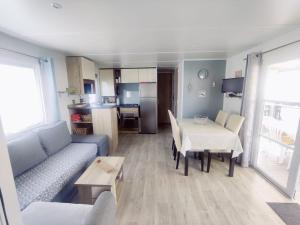 salon z kanapą i stołem oraz kuchnia w obiekcie Mobil home 40 m2 camping 4* w mieście Valras-Plage