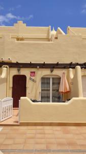 a building with a porch with an umbrella on it at Casa Donn - El Sultán 63 - luxury 3 bed Villa with fast fibre internet in Corralejo