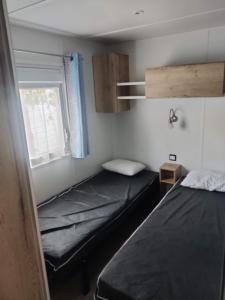 2 łóżka w małym pokoju z oknem w obiekcie Mobil home 40 m2 camping 4* w mieście Valras-Plage +6 zdjęć