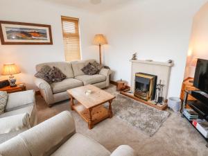 a living room with a couch and a fireplace at Eusebank in Pooley Bridge