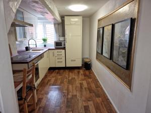 een keuken met een wastafel en een houten vloer bij Tilly Apartment in Hannoversch Münden