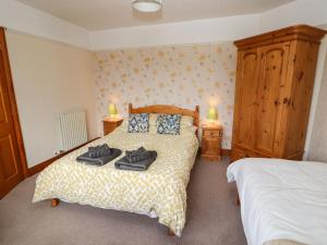 een slaapkamer met een bed met twee handdoeken erop bij Eusebank in Pooley Bridge