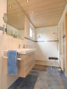 baño con lavabo, espejo y taburete en Fewo am Hochscheid, en Sankt Ingbert