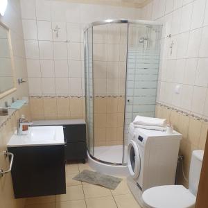 ウストカにあるApartament na Wydmie Ustkaのバスルーム(シャワー、洗濯機付)