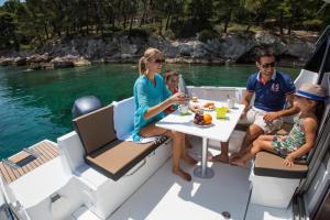 a group of people sitting around a table on a boat at Merry Fisher 795 - Iwona in Lucija