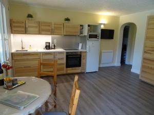 a kitchen with a white refrigerator and a table at Gîte et chambre d'hôtes Chez Marie in Compeyre
