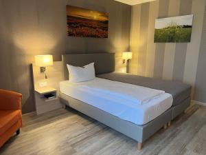 uma cama num quarto com duas lâmpadas e uma cama sidx sidx em Landhotel Felchow em Felchow