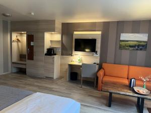 um quarto de hotel com uma cama, um sofá e uma secretária em Landhotel Felchow em Felchow