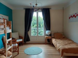 um quarto com uma cama e uma grande janela em La Maucannière em Joué-lés-Tours