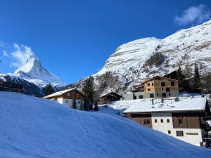 un villaggio nella neve con una montagna sullo sfondo di Chalet Coral und Zermatter Stadel a Zermatt