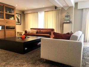 a living room with a couch and a coffee table at Grand appartement avec terrasse in Knokke-Heist
