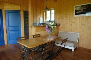 a dining room table with a vase of flowers on it at Maison en bois dans un pré in Nuits-sur-Armançon