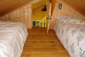 a bedroom with two beds in a wooden cabin at Maison en bois dans un pré in Nuits-sur-Armançon