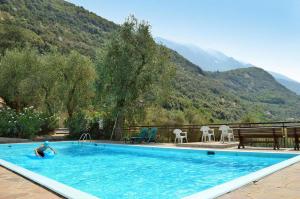 een man in een zwembad met bergen op de achtergrond bij Residence Kormorano Malcesine Apt 52 in Malcesine