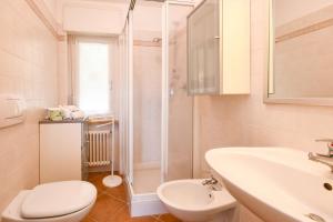 een badkamer met toilet, wastafel en douche bij Residence Kormorano Malcesine Apt 52 in Malcesine +23 foto's