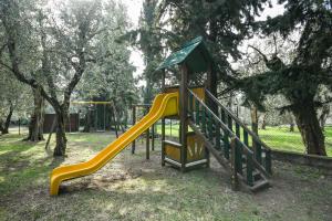 a playground with a yellow slide in a park at Residence Kormorano Malcesine Apt 52 in Malcesine