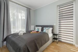a bedroom with a large bed and a large window at Apartment with Parking 500 m from The Sea by Renters in Międzywodzie