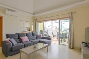 a living room with a couch and a table at Penthouse Papoila in Cabanas de Tavira