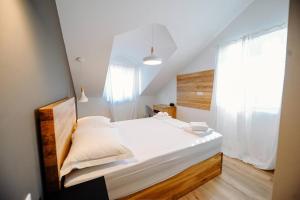 - une chambre avec un grand lit blanc et une fenêtre dans l'établissement Apartments Nives, à Stari Grad