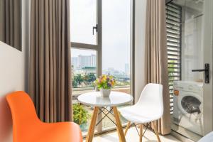 een kamer met een tafel en stoelen en een groot raam bij Stylish Studio The Tresor in Ho Chi Minh-stad