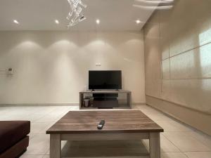 Premium 2 Bedroom Flat في المنامة: غرفة معيشة مع تلفزيون وطاولة قهوة