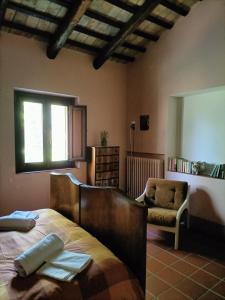um quarto com uma cama, uma cadeira e uma janela em Aromi di casa em Pianella