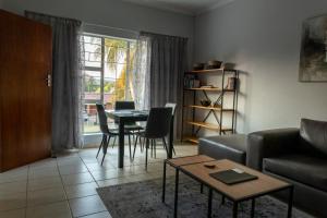 uma sala de estar com um sofá e uma mesa em VillaZek a modern 2 bedroom open- plan apartment with parking em Pretoria