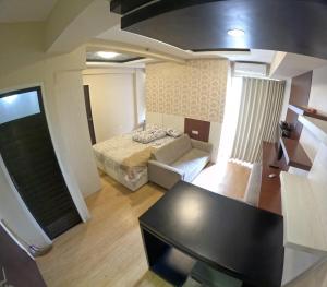 um pequeno quarto com uma cama e um sofá em We Stay Apartemen at Babarsari A3-18 em Seturan